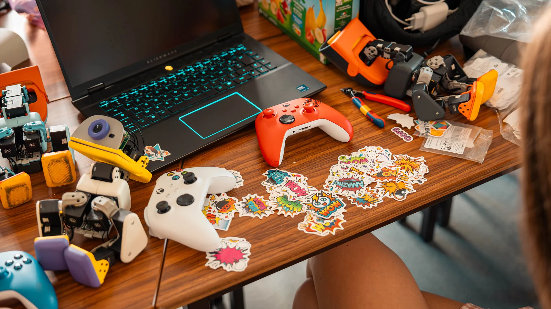 A desk with Microducks, a game controller and a sticker sheet